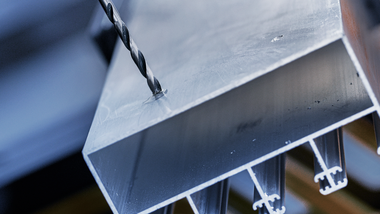 鑽頭正在厚金屬樑上鑽孔。