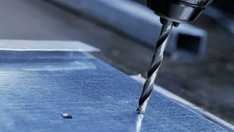 用鑽頭在金屬板上鑽孔。