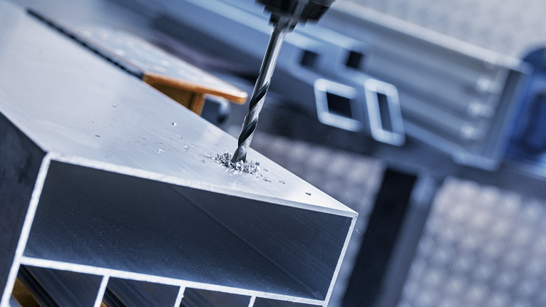 用鑽頭在金屬樑上鑽孔。