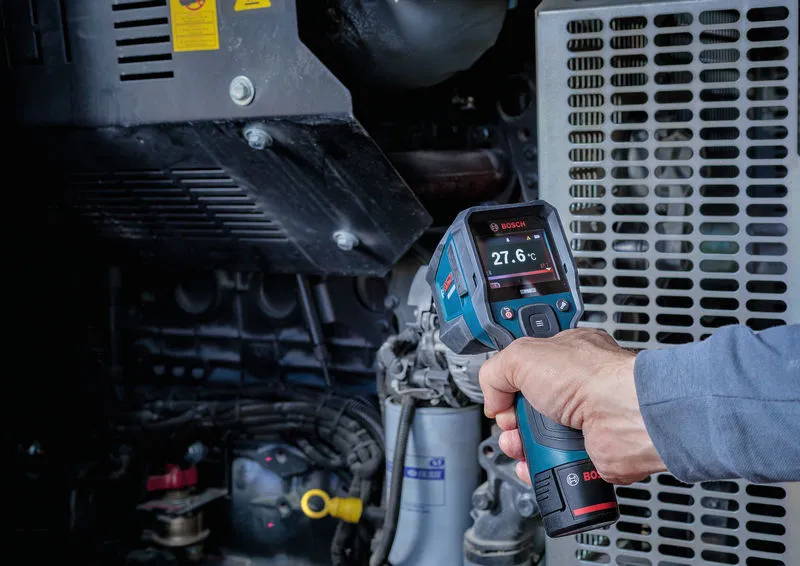 Person uses a thermo detector to measure the temperature of machinery.