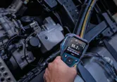 Person uses a thermo detector to check the temperature of machinery parts.